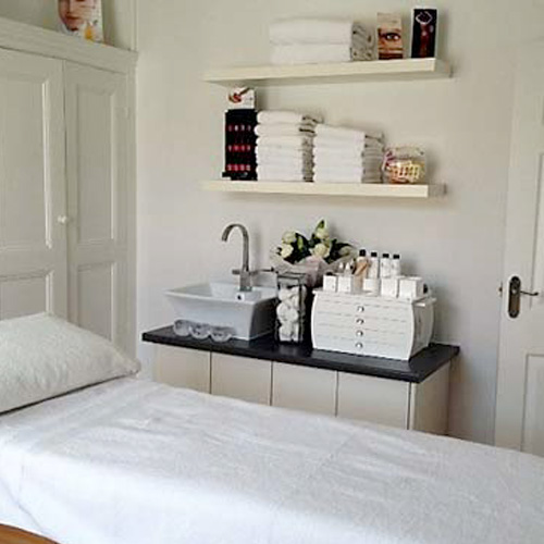 A Beauty salon couch, with neatly arranged towels in the background